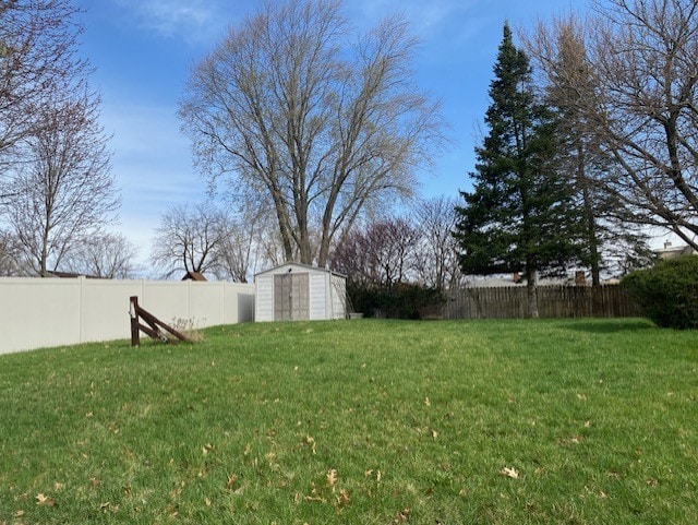 view of yard featuring an outdoor structure, a fenced backyard, and a storage shed