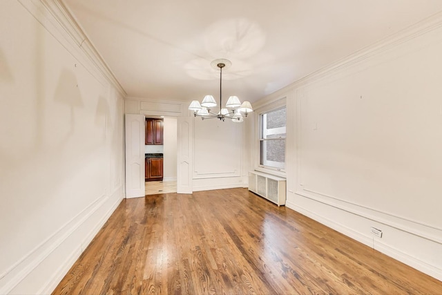 210 E Pearson St Unit 7B, Chicago, IL 60611 - unfurnished dining area with an inviting chandelier, ornamental molding, radiator, and wood finished floors