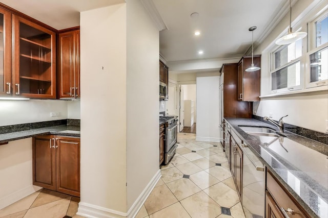 kitchen with hanging light fixtures, a sink, dark stone countertops, ornamental molding, and stainless steel appliances