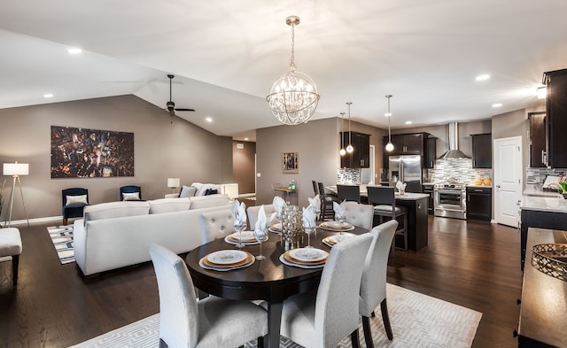 dining area with recessed lighting, ceiling fan with notable chandelier, vaulted ceiling, and dark wood finished floors