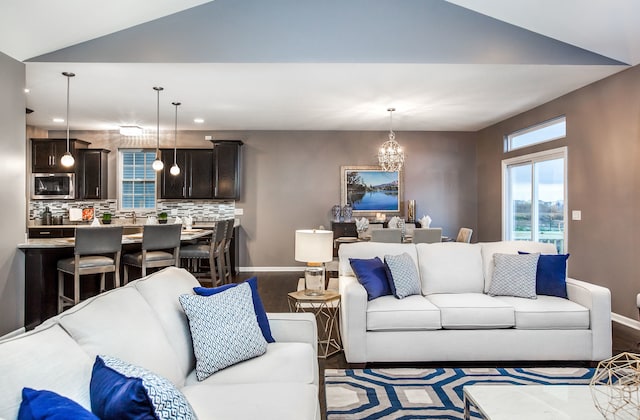 living room with recessed lighting, baseboards, an inviting chandelier, and dark wood finished floors