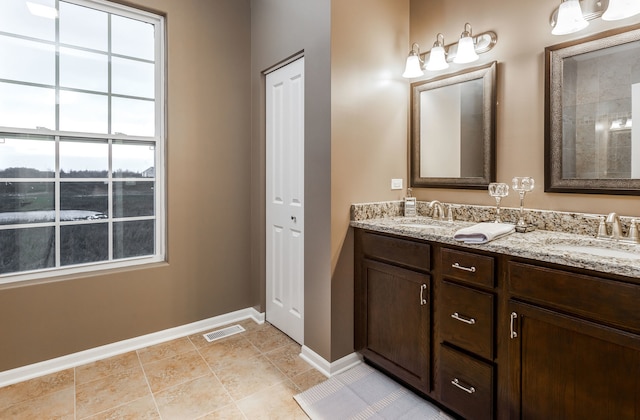 full bathroom featuring double vanity, visible vents, baseboards, and a sink