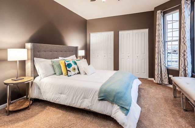 carpeted bedroom featuring baseboards, multiple windows, and multiple closets