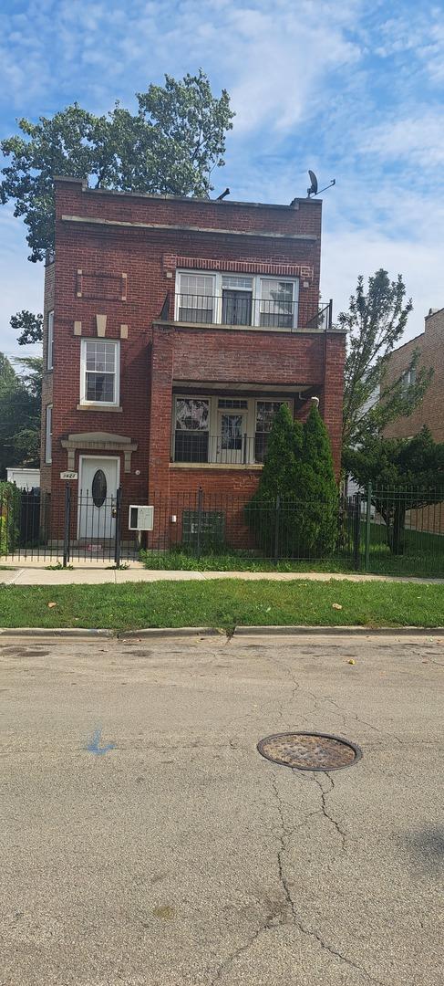 1623 S Drake Ave, Chicago, IL 60623 - view of front of house featuring a balcony, brick siding, and a fenced front yard