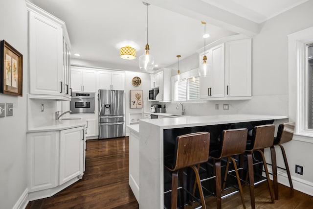 1130 Paulina St, Oak Park, IL 60302 - kitchen with dark wood-type flooring, a peninsula, white cabinetry, and stainless steel appliances