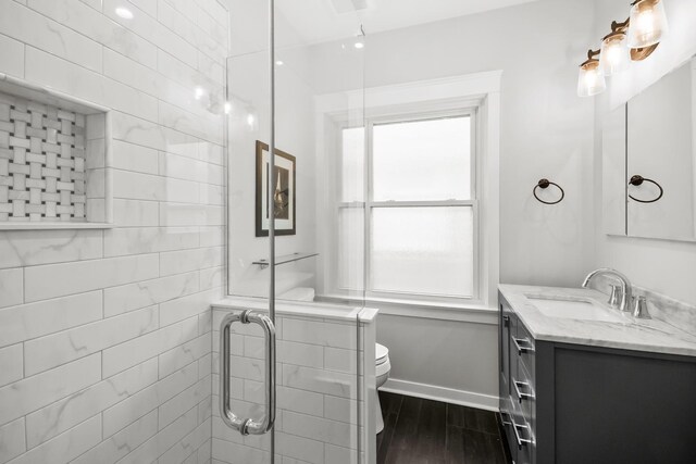 1130 Paulina St, Oak Park, IL 60302 - full bath featuring baseboards, toilet, vanity, wood finished floors, and a stall shower