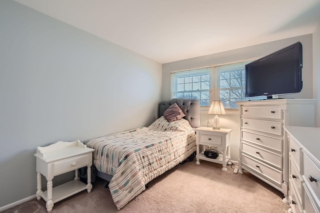 bedroom featuring light carpet and baseboards