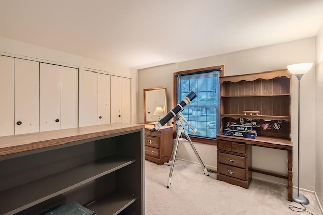 home office with baseboards and light colored carpet