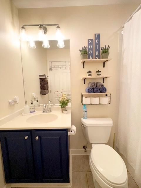 full bathroom featuring toilet, tile patterned floors, and vanity