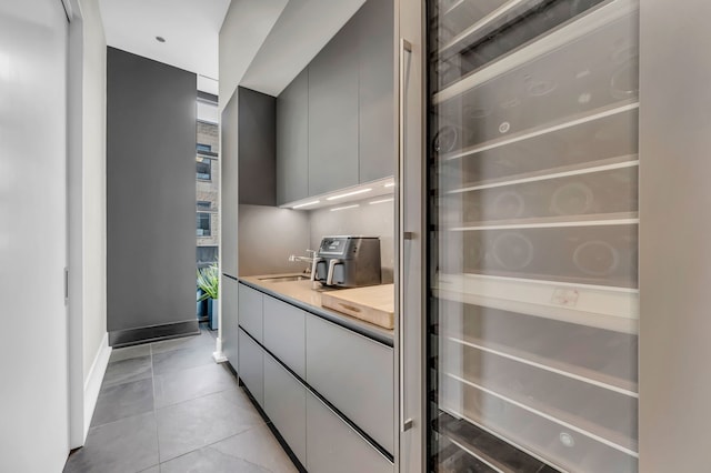 400 W Huron St Unit 501, Chicago, IL 60654 - kitchen featuring modern cabinets, a sink, beverage cooler, light tile patterned floors, and light countertops