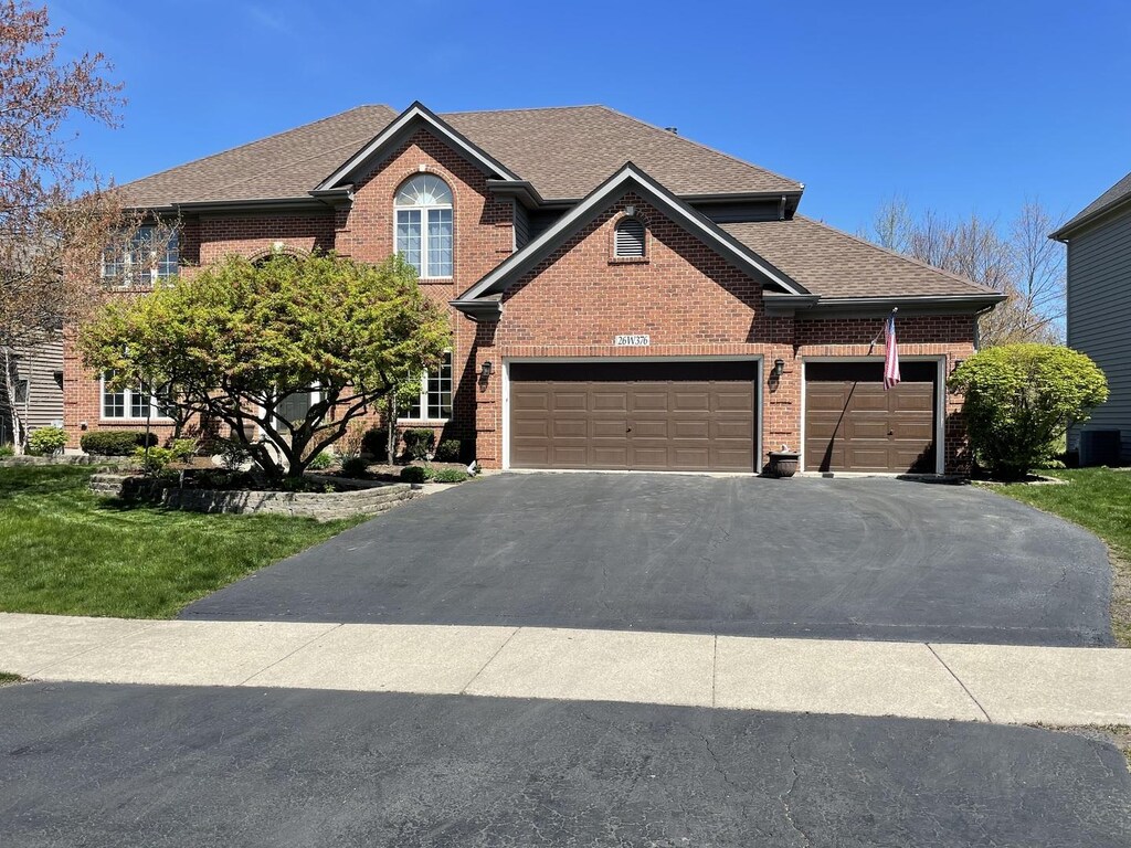 26W376 Torrey Pines Ct, Winfield, IL 60190 - view of front of home featuring brick siding, driveway, central air condition unit, and a shingled roof