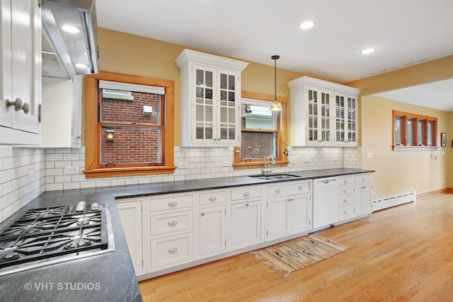kitchen featuring white cabinets, dishwasher, a sink, stainless steel gas stovetop, and a baseboard heating unit