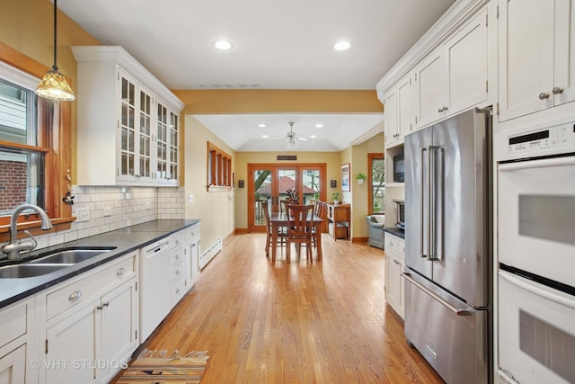 kitchen featuring a sink, white appliances, dark countertops, ceiling fan, and decorative backsplash