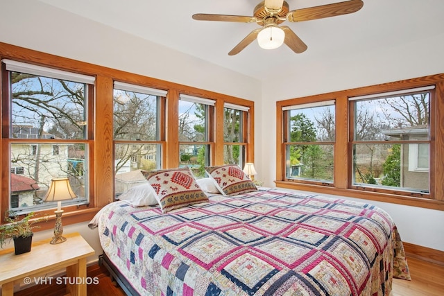bedroom with baseboards, ceiling fan, and wood finished floors