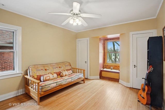 sitting room featuring crown molding, light wood-style flooring, ceiling fan, and baseboards