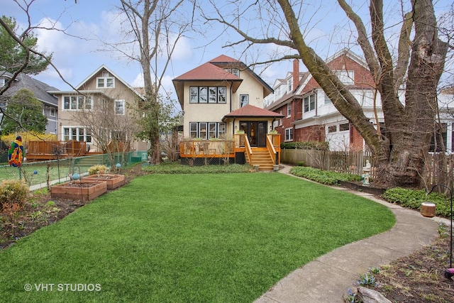 view of yard with a garden, a deck, and fence private yard