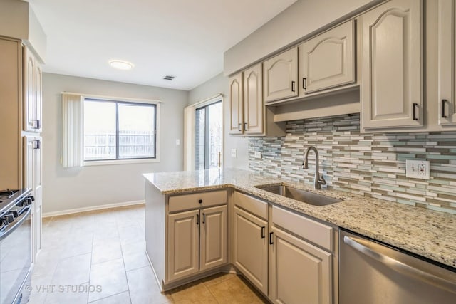 920 Surrey Dr Unit 1A, Schaumburg, IL 60193 - kitchen featuring tasteful backsplash, a sink, a peninsula, stainless steel appliances, and baseboards
