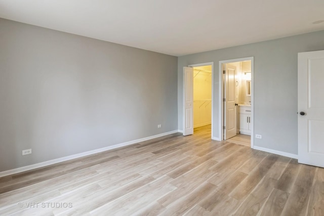 920 Surrey Dr Unit 1A, Schaumburg, IL 60193 - unfurnished bedroom with a spacious closet, light wood finished floors, a closet, baseboards, and ensuite bathroom