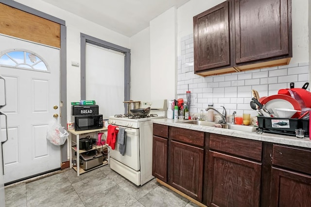 4734 W Monroe St, Chicago, IL 60644 - kitchen featuring light countertops, tasteful backsplash, a sink, black microwave, and gas range gas stove