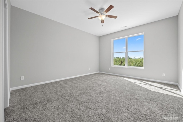unfurnished room with a ceiling fan, baseboards, and carpet