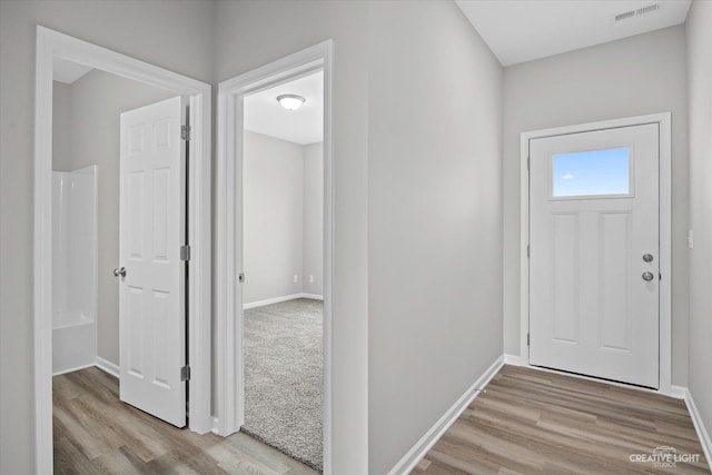 entryway with visible vents, baseboards, and wood finished floors