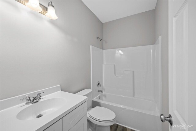 full bathroom with shower / bathing tub combination, wood finished floors, vanity, and toilet