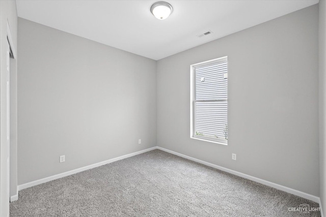 unfurnished room featuring visible vents, baseboards, carpet, and a healthy amount of sunlight
