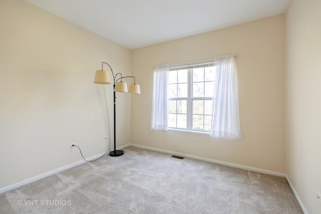 unfurnished room with baseboards, carpet flooring, and visible vents