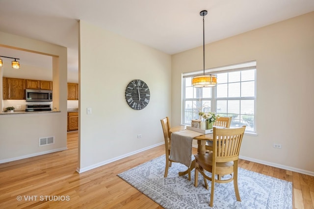 dining room featuring baseboards, visible vents, and light wood-style flooring