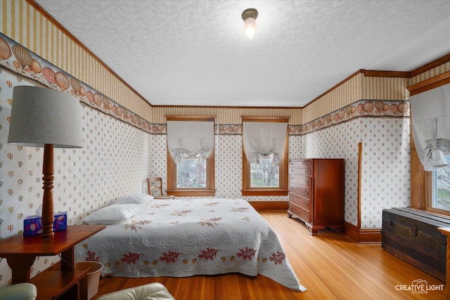 416 Stilson St, Earlville, IL 60518 - bedroom featuring crown molding, light wood-style flooring, a textured ceiling, and wallpapered walls