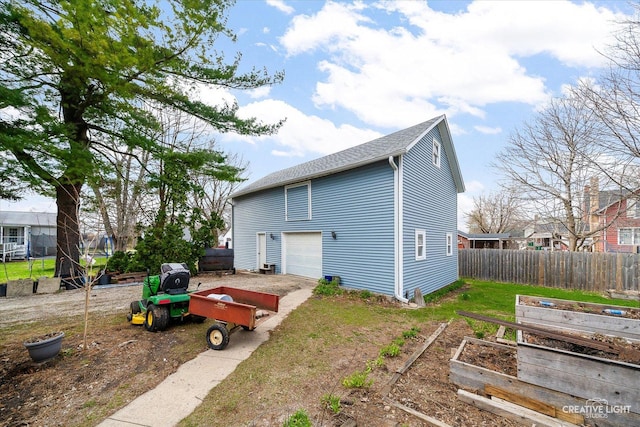416 Stilson St, Earlville, IL 60518 - exterior space with a garage, driveway, fence, and a vegetable garden