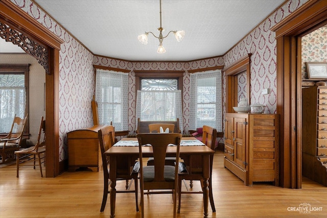 416 Stilson St, Earlville, IL 60518 - dining room featuring a wealth of natural light, light wood-style flooring, wallpapered walls, and a chandelier
