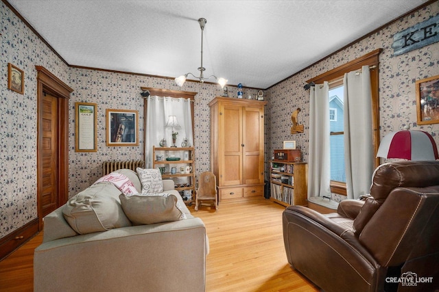 416 Stilson St, Earlville, IL 60518 - living room featuring ornamental molding, a textured ceiling, light wood finished floors, radiator, and wallpapered walls