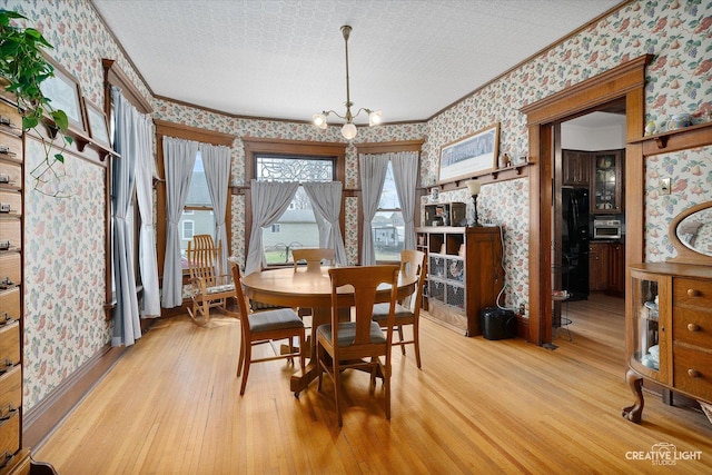 416 Stilson St, Earlville, IL 60518 - dining room featuring light wood-type flooring, an inviting chandelier, wallpapered walls, a textured ceiling, and crown molding