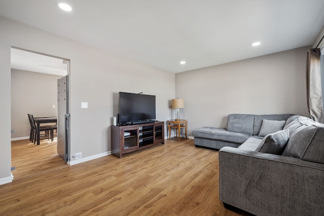 living room featuring baseboards, recessed lighting, and light wood-style floors