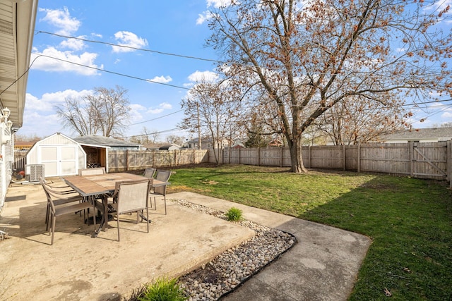 view of yard with a fenced backyard, a patio area, a storage unit, and outdoor dining area