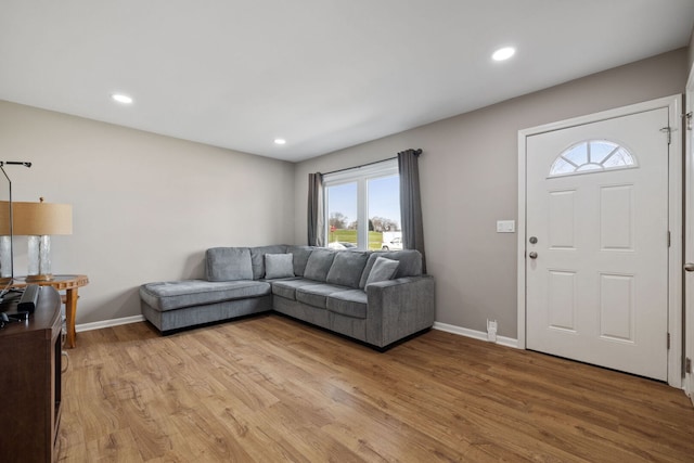 living area featuring plenty of natural light, light wood finished floors, and baseboards