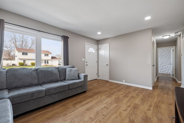 living room featuring baseboards, light wood-style flooring, and recessed lighting