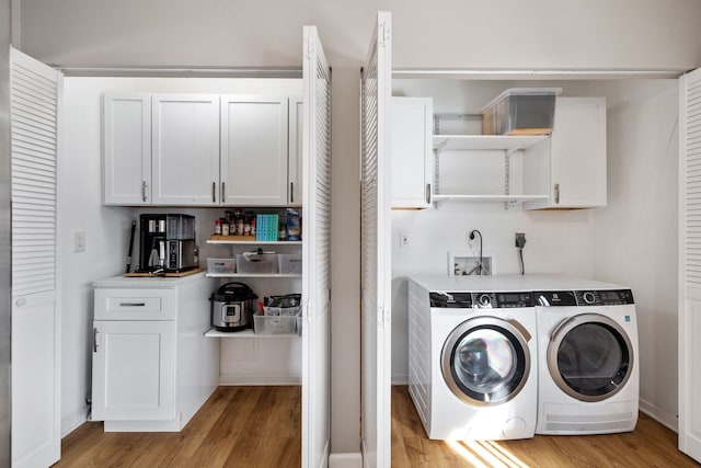 washroom featuring washing machine and dryer, light wood-style flooring, baseboards, and laundry area