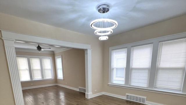 325 W 107th St, Chicago, IL 60628 - spare room featuring a chandelier, baseboards, dark wood-type flooring, ceiling fan, and decorative columns