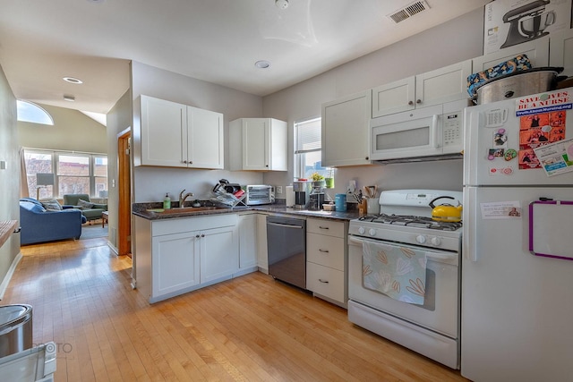 530 N Ashland Ave, Chicago, IL 60622 - kitchen with visible vents, plenty of natural light, dark countertops, white appliances, and light wood finished floors