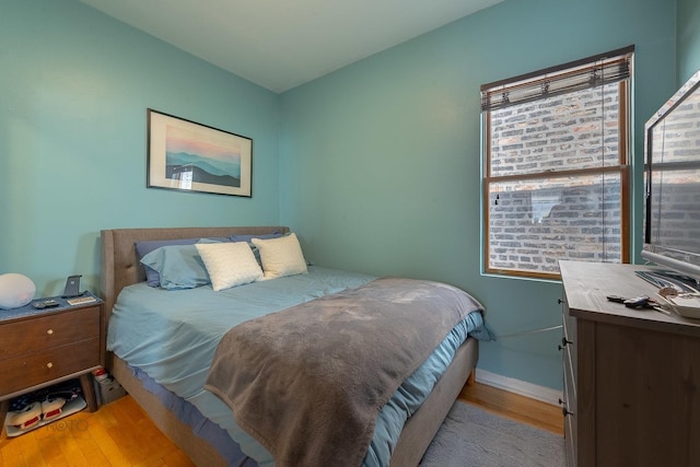 530 N Ashland Ave, Chicago, IL 60622 - bedroom featuring multiple windows, baseboards, and wood finished floors