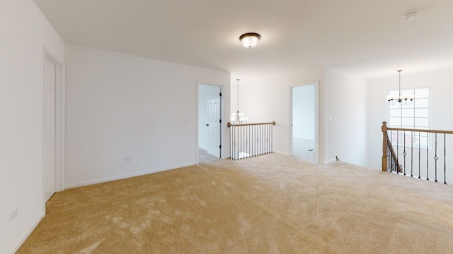 carpeted empty room featuring a chandelier
