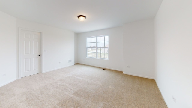 spare room featuring carpet floors, baseboards, and visible vents