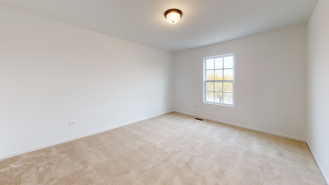 spare room with visible vents, baseboards, and carpet