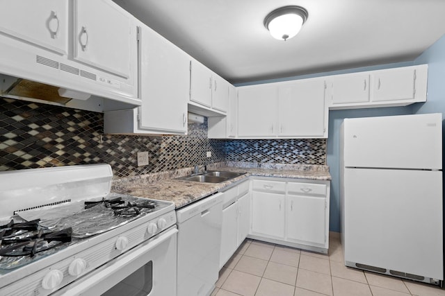 kitchen with light tile patterned flooring, tasteful backsplash, under cabinet range hood, and white appliances