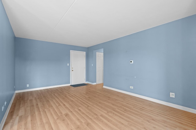 unfurnished room with baseboards and light wood-type flooring