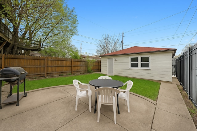 view of patio / terrace with grilling area, an outbuilding, outdoor dining area, and a fenced backyard