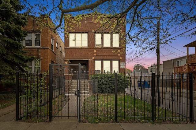 view of front of property featuring a gate, a fenced front yard, and brick siding