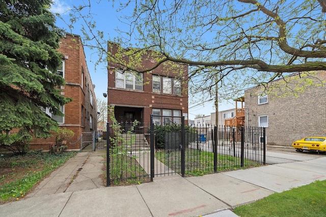 view of front of house with brick siding, a gate, and a fenced front yard
